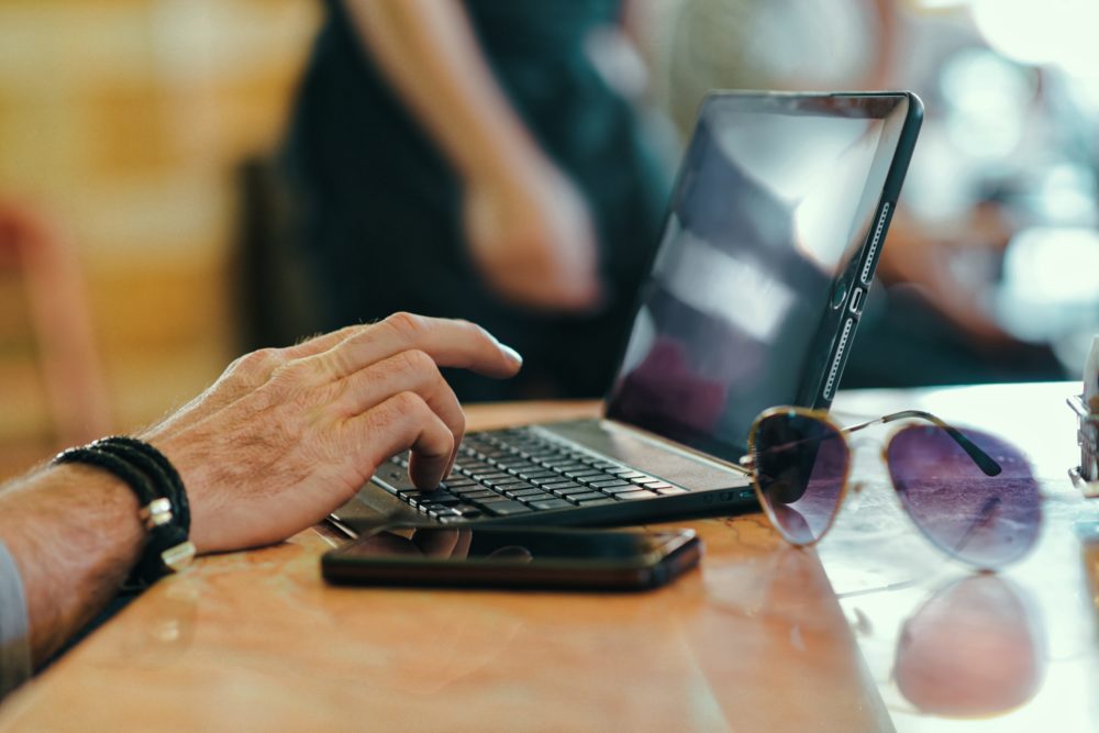 older man's hand on laptop