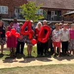 York Place 40th anniversary, group of tenants and members holding celebration 40th balloons