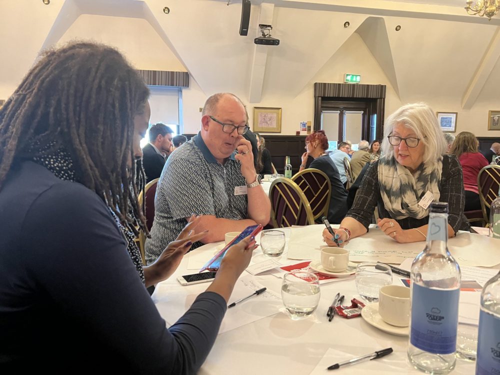 Independent East Conference November 2022,3 delegates chatting at table